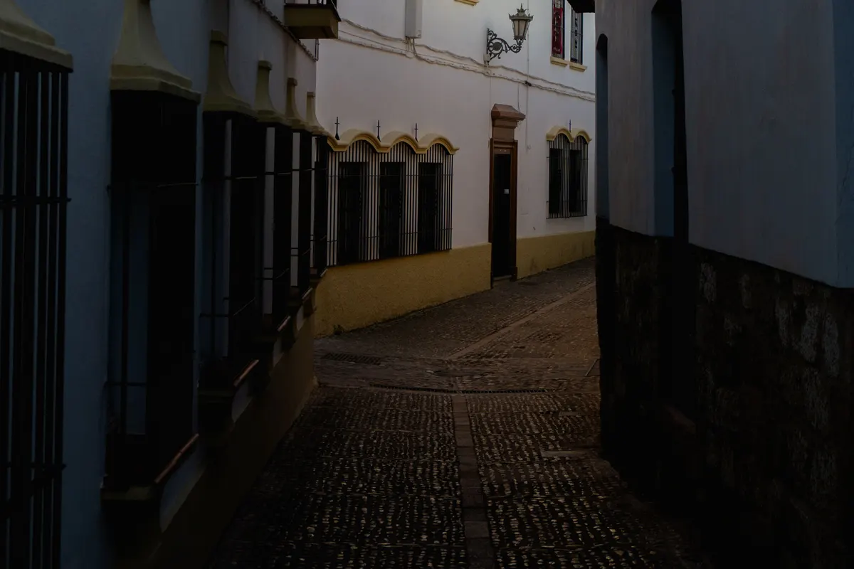 Calle estrecha con casas blancas en un casco histórico andaluz, imagen ilustrativa