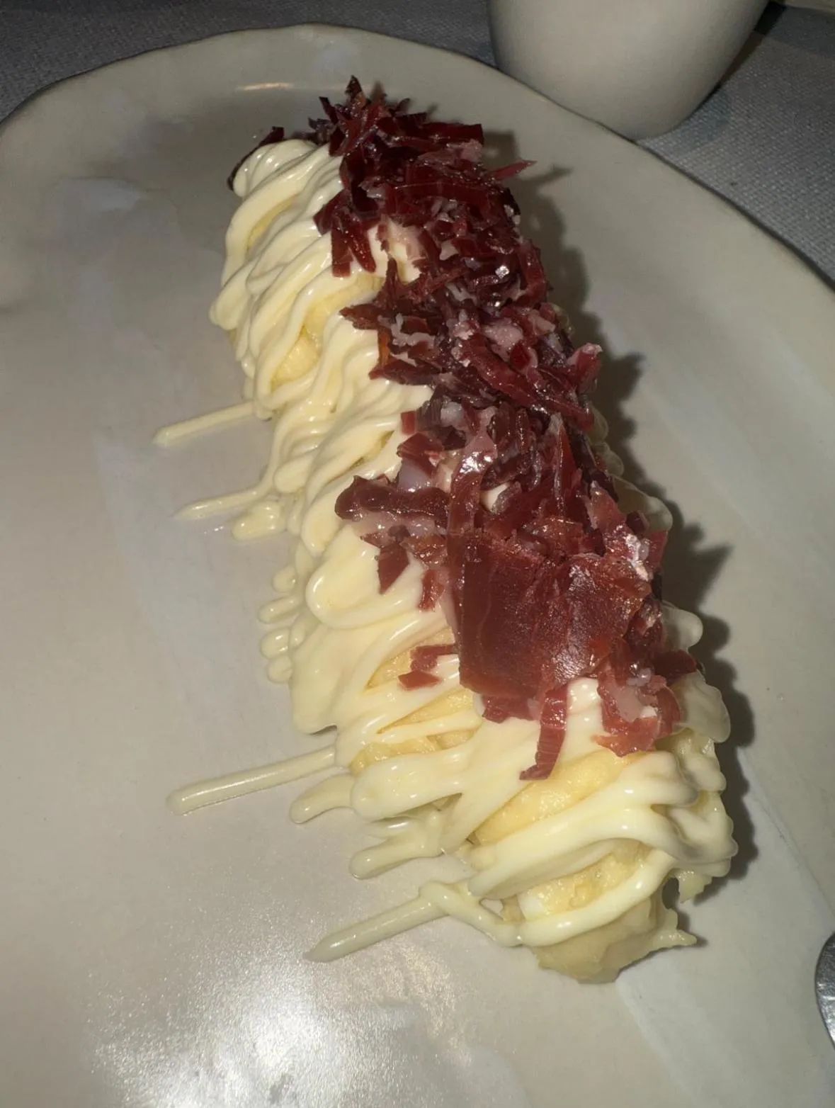 Ensaladilla rusa con jamón ibérico de Tragabuches, cubierta de mayonesa y virutas de jamón
