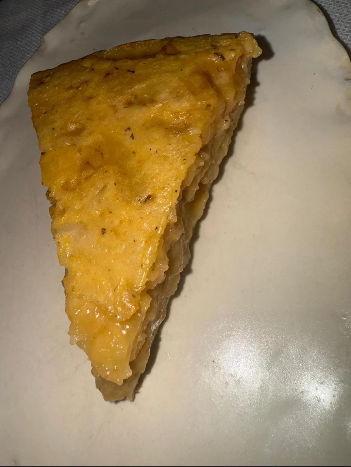 Tortilla de patatas al estilo Dani García, una porción jugosa servida en plato de cerámica